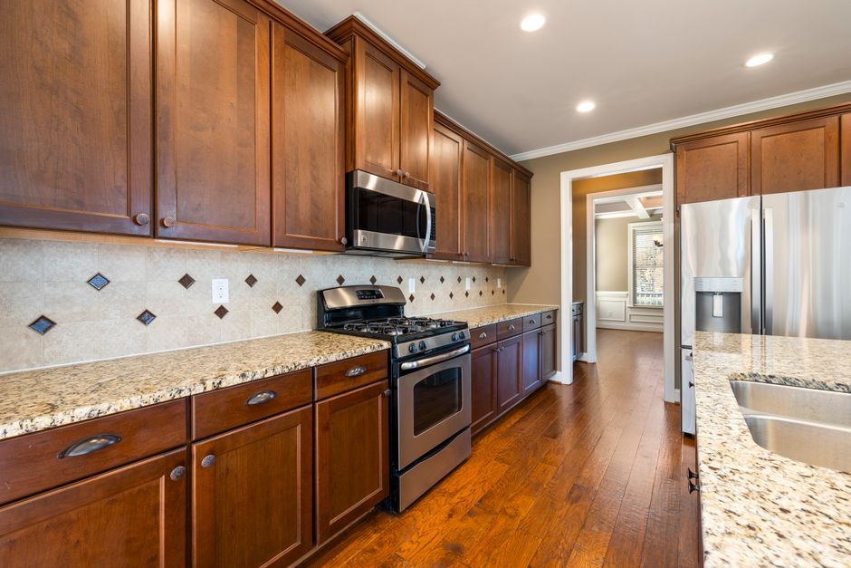 Elegant modern kitchen featuring wooden cabinets, stainless steel appliances, and granite countertops.